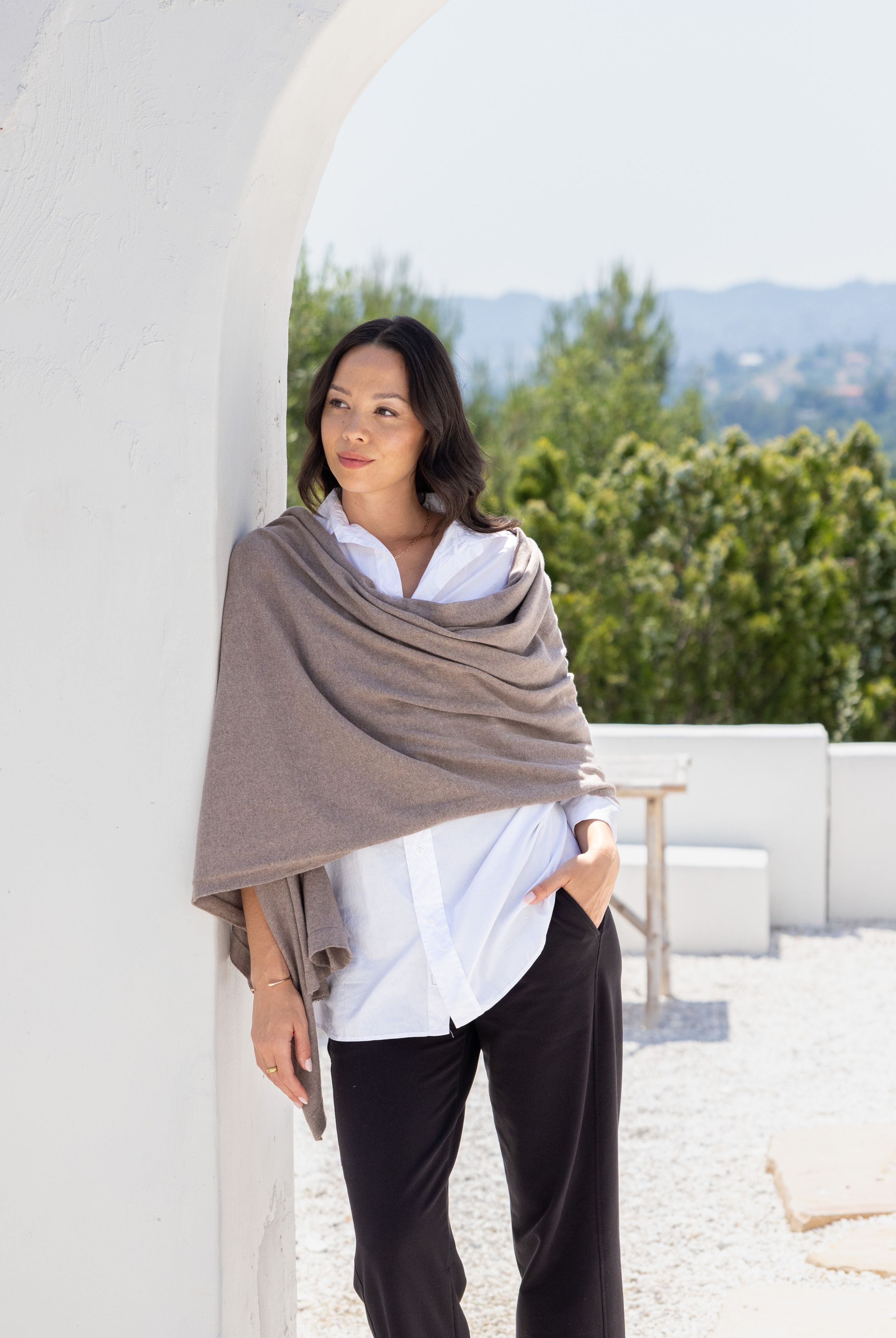 Women shown wearing a dark beige scarf draped over her shoulders